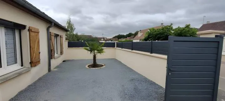 Cour gravillonnée avec mur et portail
